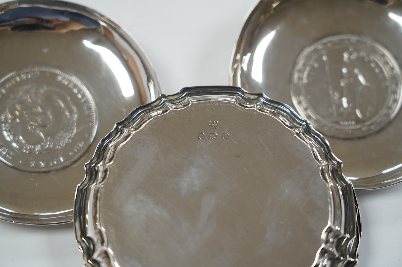 A pair of George V silver pedestal bonbon dishes, Birmingham, 1916, diameter 12.7cm, a set of four similar silver glass coasters, a silver bonbon bowl and a pair of Chinese white metal dishes with inset coin bases by Wan